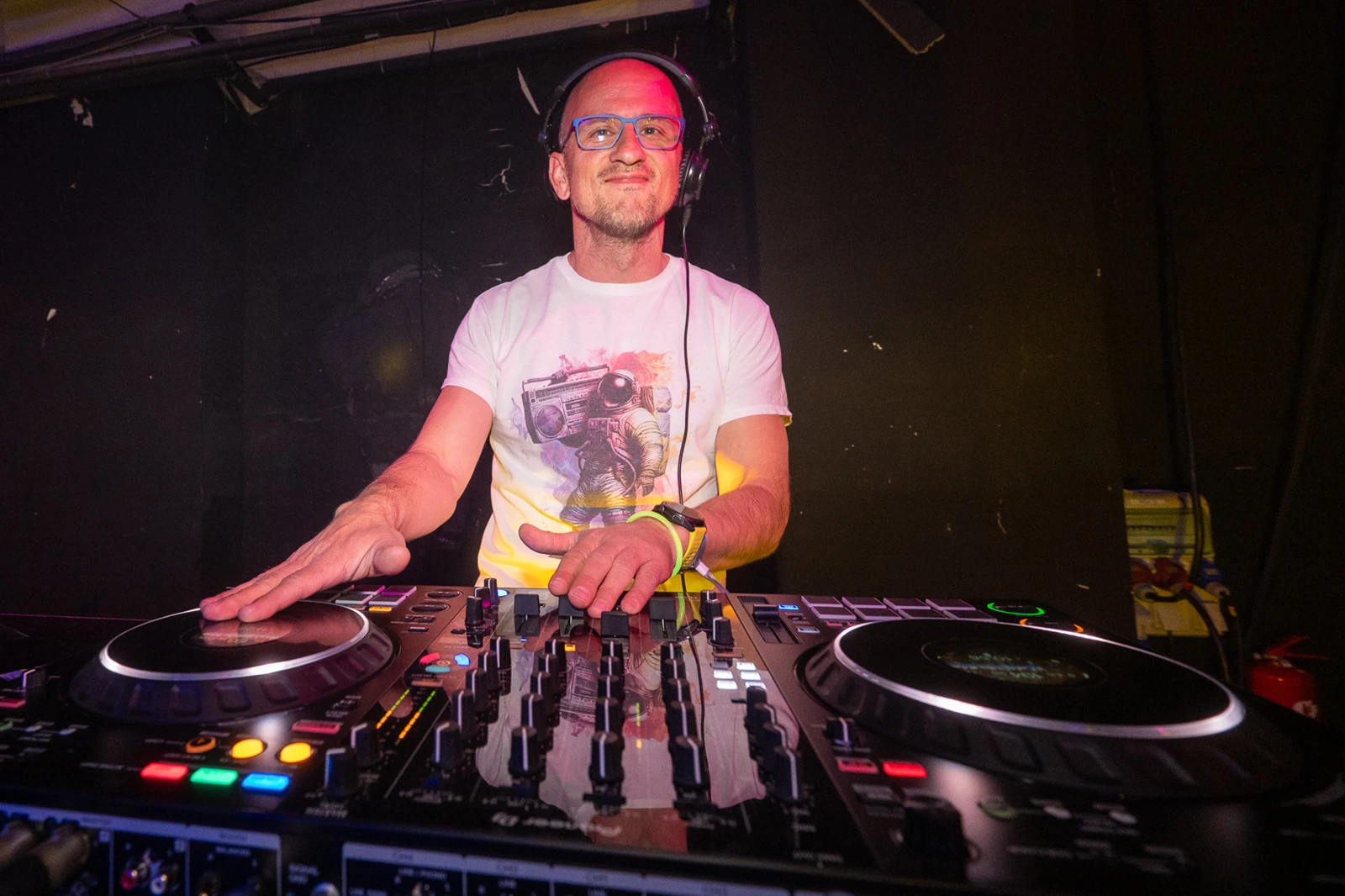 DJ Sommer za DJ pultom, s rukama na mikseru i playerima